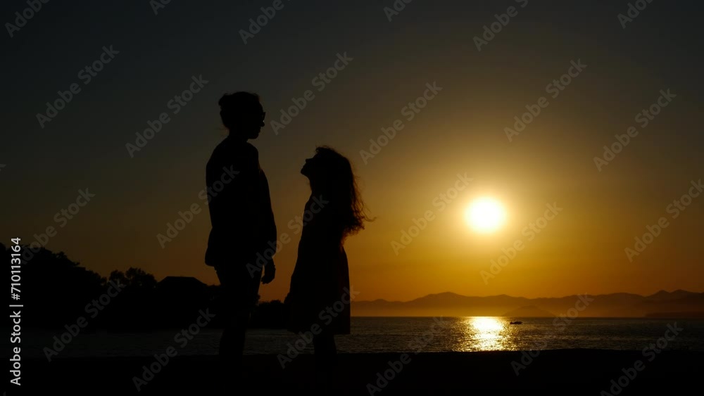 Happy family on bay during dusk. A child love her mother and hugs in the sunset rays on the seashore during summer holidays. Happy family on bay during dusk. A child love her mother and hugs in the sunset rays on the seashore during summer holidays.