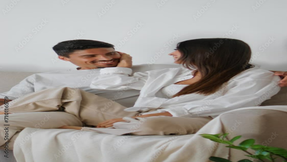Smiling couple embracing sofa vertically closeup. Woman stroking man relaxing Smiling couple embracing sofa vertically closeup. Woman stroking man relaxing