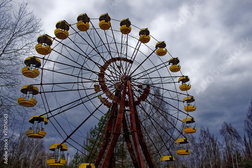 A weathered Ferris wheel stands tall amidst bare trees.