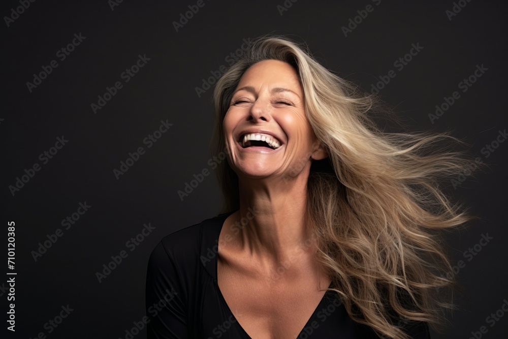 Portrait of a happy mature woman laughing with her hair blowing in the wind. Portrait of a happy mature woman laughing with her hair blowing in the wind.