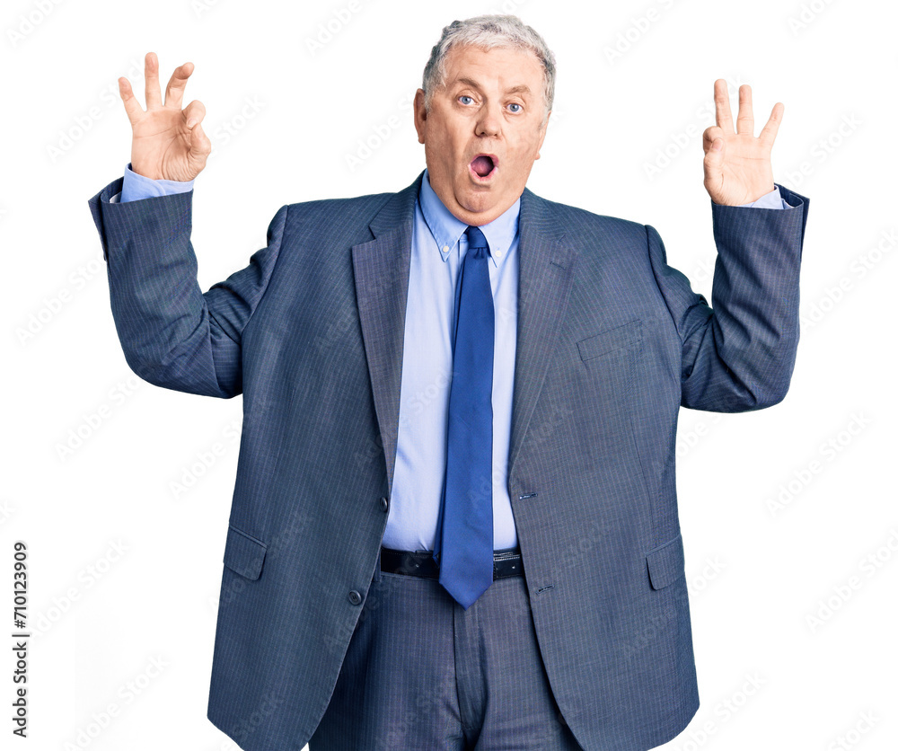 Senior grey-haired man wearing business jacket looking surprised and shocked doing ok approval symbol with fingers. crazy expression Senior grey-haired man wearing business jacket looking surprised and shocked doing ok approval symbol with fingers. crazy expression