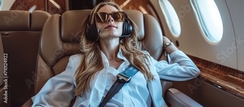 Joyful female executive enjoying music on a private aircraft.
