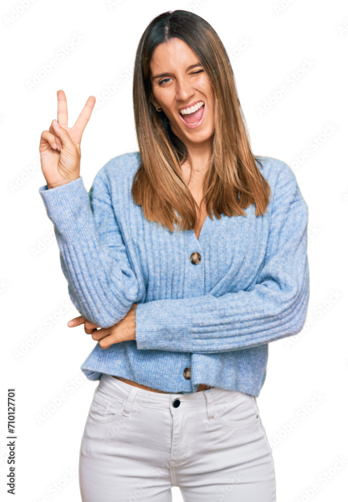 Young woman wearing casual clothes smiling with happy face winking at the camera doing victory sign with fingers. number two. Young woman wearing casual clothes smiling with happy face winking at the camera doing victory sign with fingers. number two.