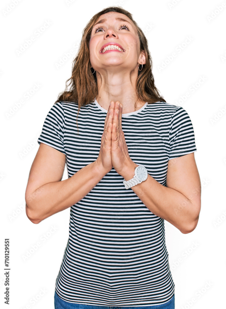 Young blonde woman wearing casual clothes begging and praying with hands together with hope expression on face very emotional and worried. begging. Young blonde woman wearing casual clothes begging and praying with hands together with hope expression on face very emotional and worried. begging.