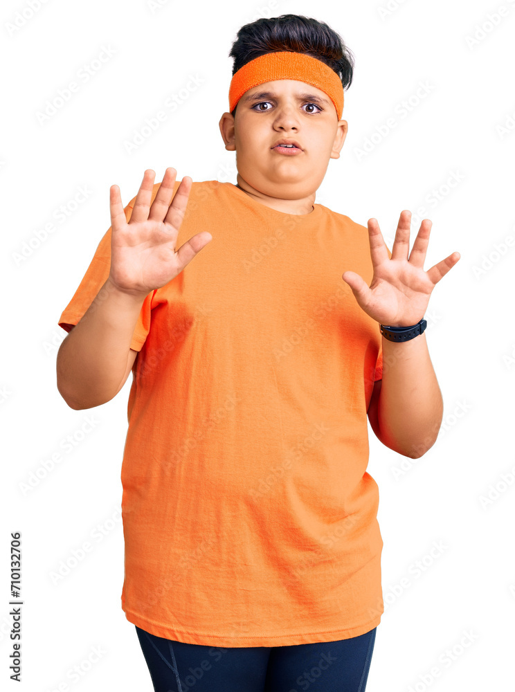 Little boy kid wearing sportswear afraid and terrified with fear expression stop gesture with hands, shouting in shock. panic concept.
