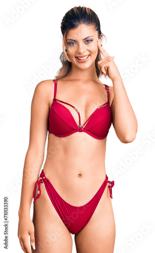 Young beautiful woman wearing bikini smiling pointing to head with one finger, great idea or thought, good memory © Krakenimages.com