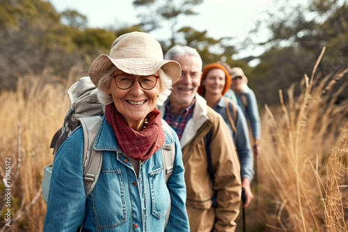 A group of active older friends enjoy hiking in the countryside, walking together along a trail