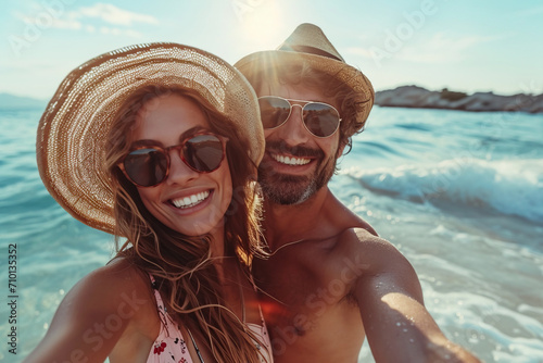 A portrait, playful and happy couple on the beach during their vacation on a tropical island, along with waves, love and hugs
