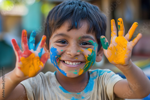 A smiling boy with painted hands and face