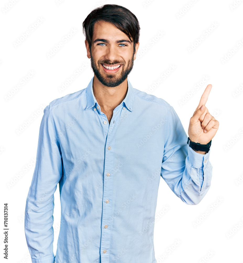 Hispanic man with blue eyes wearing business shirt with a big smile on face, pointing with hand finger to the side looking at the camera. Hispanic man with blue eyes wearing business shirt with a big smile on face, pointing with hand finger to the side looking at the camera.