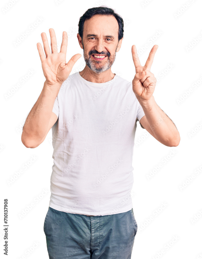 Fototapeta premium Middle age handsome man wearing casual t-shirt showing and pointing up with fingers number seven while smiling confident and happy.