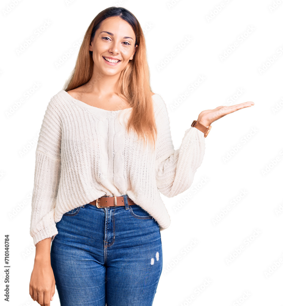 Beautiful young woman wearing casual clothes smiling cheerful presenting and pointing with palm of hand looking at the camera. Beautiful young woman wearing casual clothes smiling cheerful presenting and pointing with palm of hand looking at the camera.