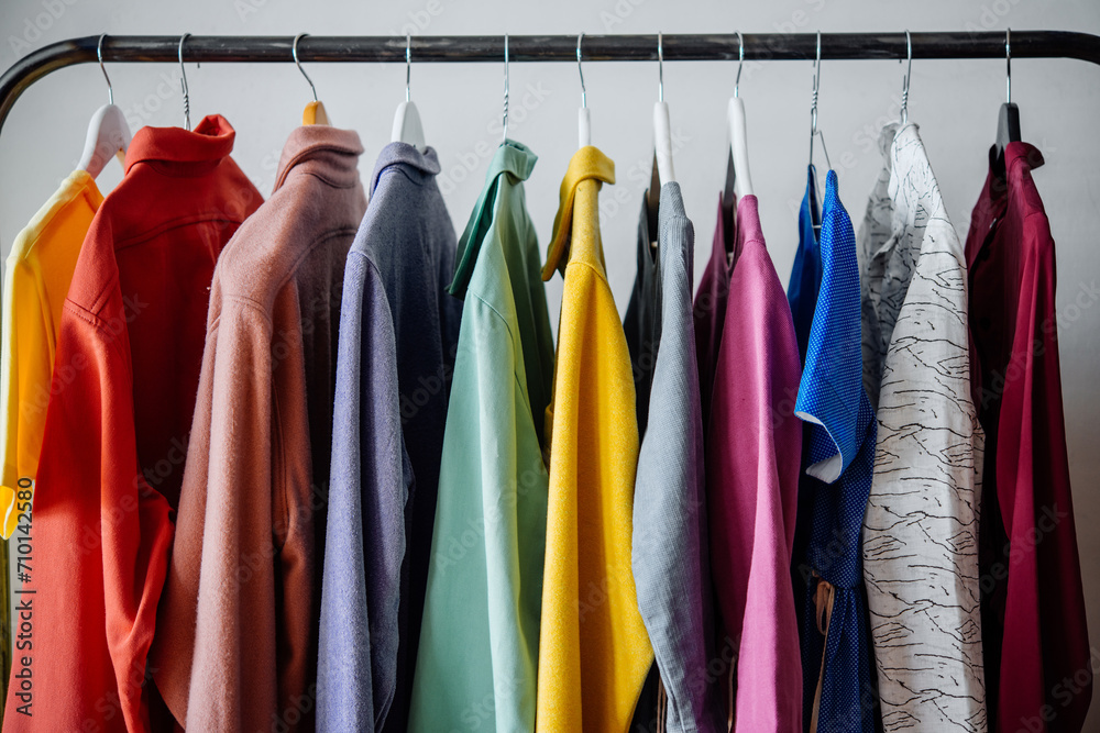 Colorful women's clothes on hangers in a retail shop. Fashion and shopping concept.