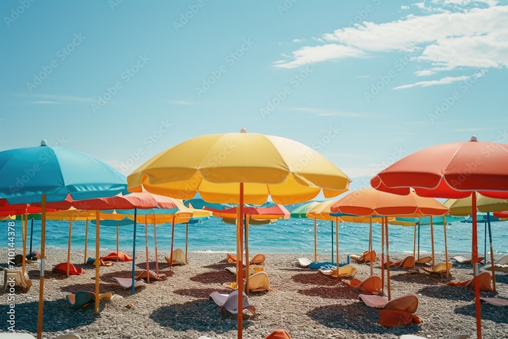 Colorful umbrellas lined up on a sandy beach. Perfect for beach or summer-themed designs