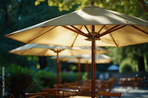 A row of tables with colorful umbrellas set up for outdoor seating on a bright and sunny day. Perfect for illustrating outdoor dining, leisure activities, and summer vibes photo