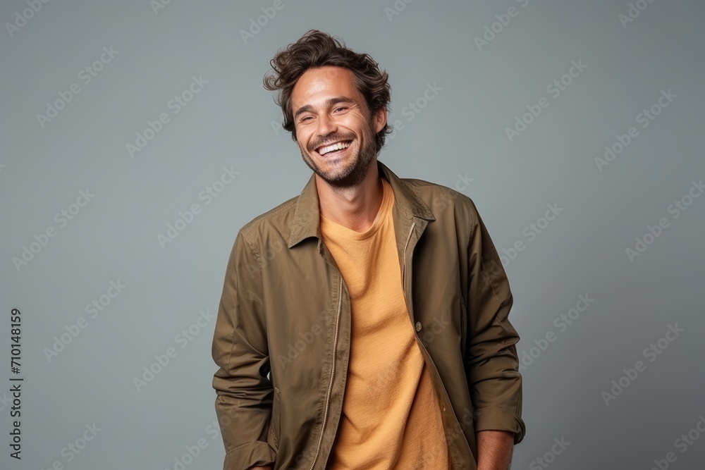 Portrait of a handsome young man laughing against a grey background. Portrait of a handsome young man laughing against a grey background.