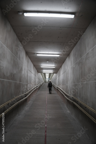 Girl walking in a train station tunnel