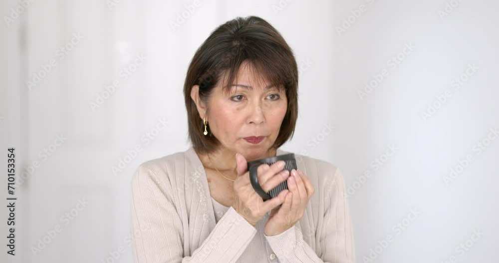 Attractive stylish woman relaxing enjoying drinking coffee holding cup looking at camera in bright room close up. Attractive stylish woman relaxing enjoying drinking coffee holding cup looking at camera in bright room close up.
