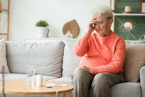 Sick senior woman with pills at home