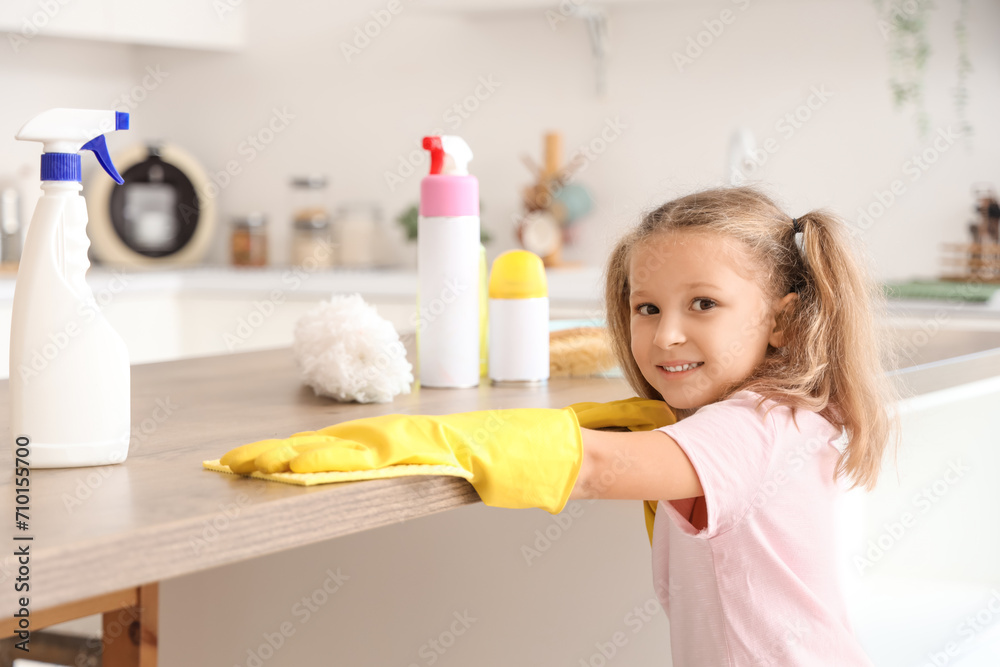 Cute little girl cleaning table in kitchen Cute little girl cleaning table in kitchen