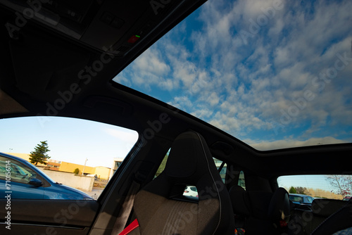 Blue cloudscape on a panoramic glass roof in a car