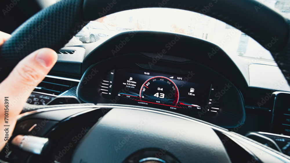Digital screen dashboard in a sports car cockpit with odometer close up still