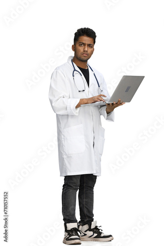 male doctor on a white background. uses a laptop at full height