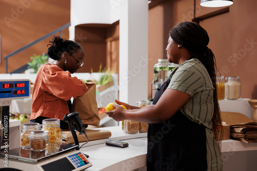 African American woman and female seller stand at local market surrounded by fresh produce and organic food. The market supports local farmers and offers natural options for eco-friendly consumers.