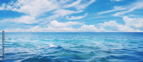 Clear blue sea with waves and cloudy sky.