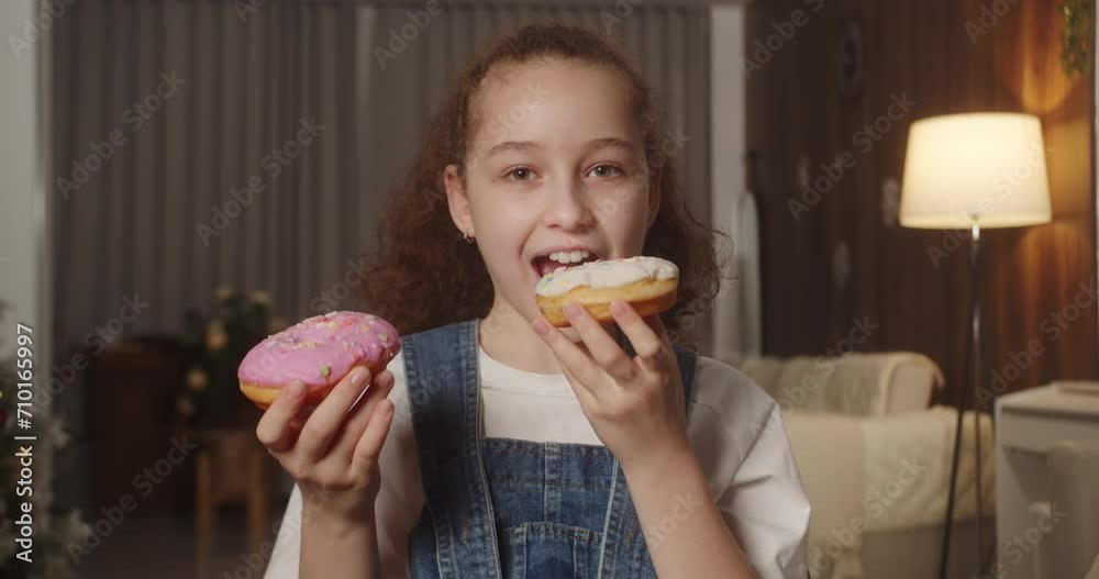 Portrait happy child 11 years old eats an appetizing sweet dessert donut in glaze. Cheerful Caucasian little girl eats a sweet donut. Close-up of the mouth of a child eating sweet pastries. 4K. Portrait happy child 11 years old eats an appetizing sweet dessert donut in glaze. Cheerful Caucasian little girl eats a sweet donut. Close-up of the mouth of a child eating sweet pastries. 4K.