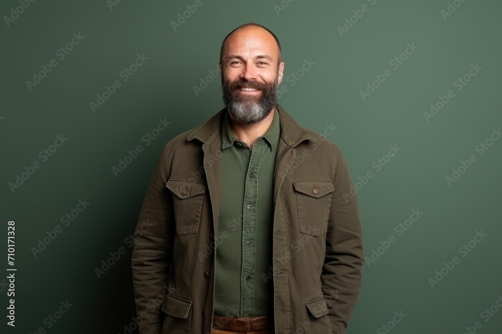 Portrait of a smiling middle-aged man standing against green background Portrait of a smiling middle-aged man standing against green background