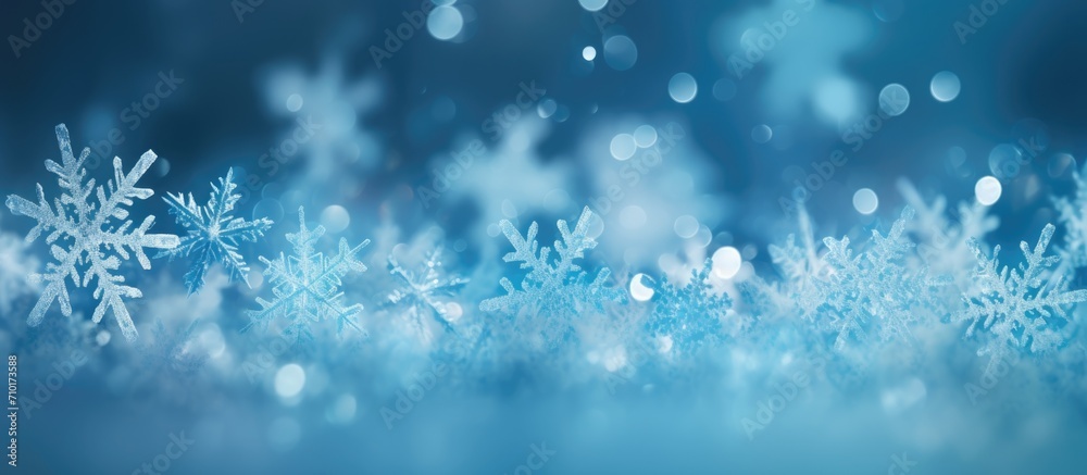 Blue background with bokeh in the shape of snowflakes.