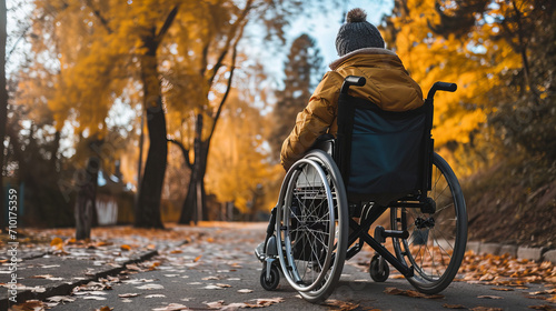 disabled person on a wheelchair in the autumnal park © Christopher