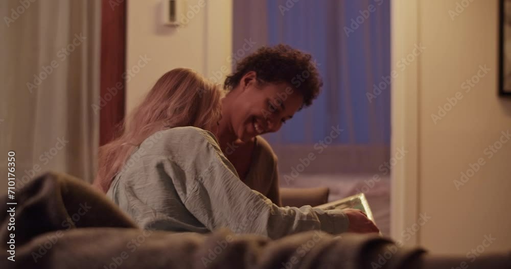Diverse girlfriends watching photo album in living room Diverse girlfriends watching photo album in living room
