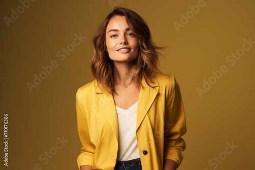 Portrait of beautiful young woman in yellow jacket over yellow background. © Igor