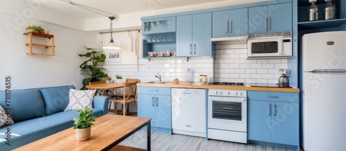 Vacation rental apartment with blue cabinets, wood grain, white appliances, exposed white brick wall, and hydraulic tile floor.