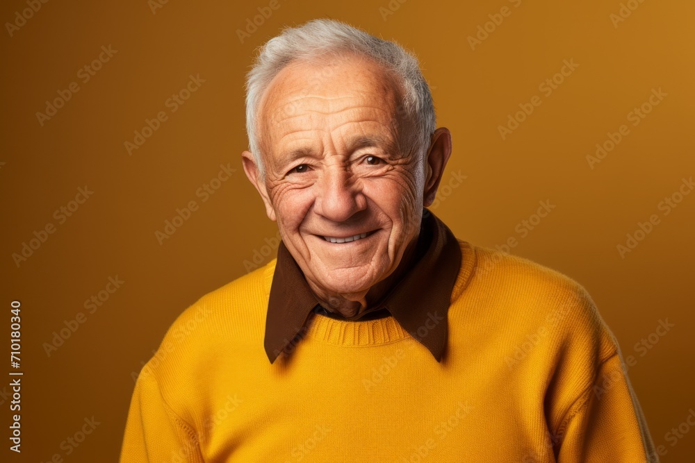 Portrait of a happy senior man in a yellow sweater on a yellow background Portrait of a happy senior man in a yellow sweater on a yellow background