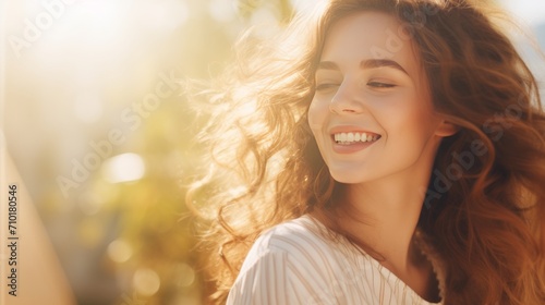 Beautiful Caucasian woman with natural makeup in the sunlight. Happy lady enjoying the sun. Banner with copy space. Ideal for beauty, wellness, lifestyle campaigns or hair care advertisements.