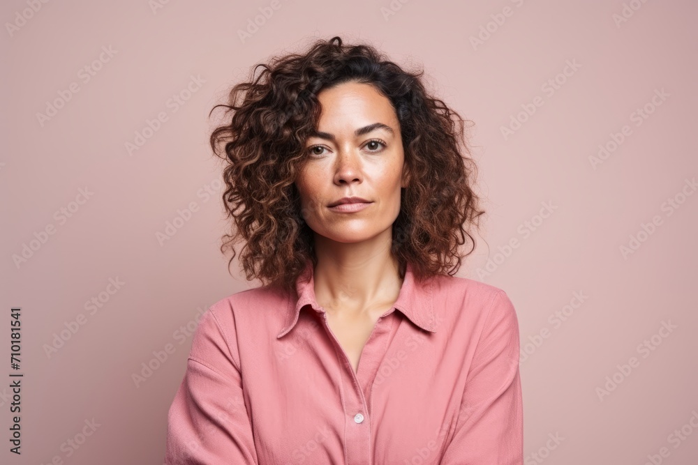 Portrait of a beautiful woman with curly hair on a pink background Portrait of a beautiful woman with curly hair on a pink background