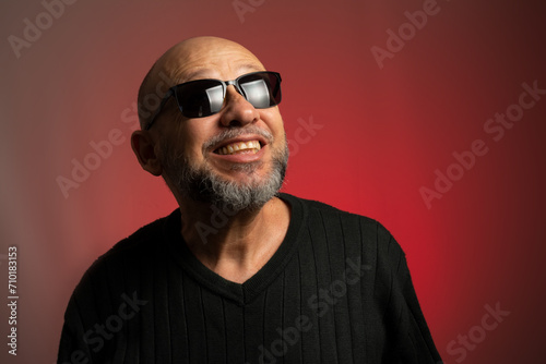Caucasian, bald man in sunglasses, confident looking up.