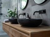 Ensuite bathroom with wall mounted timber vanity and black sink and pill shaped mirrors. Black and beige