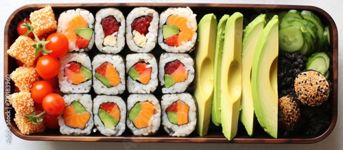 Nutritious lunchbox with chickpea nuggets, veggies, fruit, and avocado sushi.