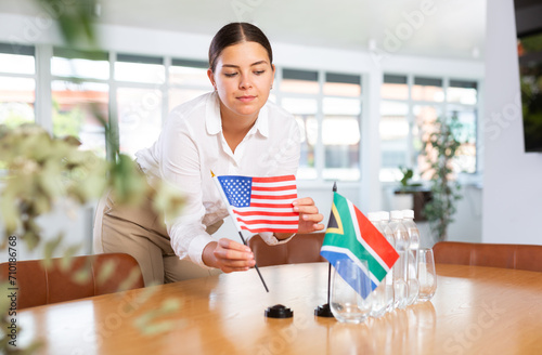 Businesswoman arranging the flags of Unitad States and South Africa for a presentation and negotiations photo