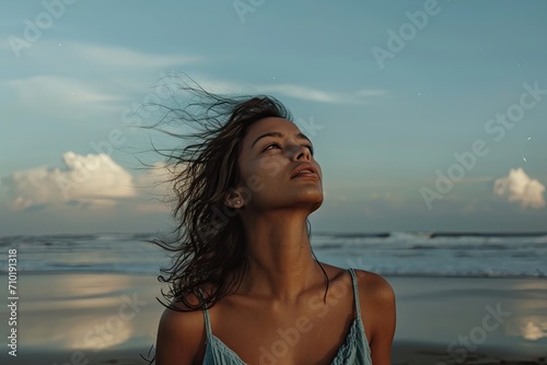 A lone woman gazes wistfully at the endless expanse of sky and ocean, embodying the freedom and serenity of a carefree summer day on the beach © AiAgency