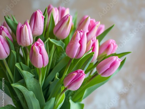 Bunch of pink spring flowers with green leaves at home  light beautiful purple tulips bouquet as nice romantic present from floral shop made by professional florist  vertical close up view copy space