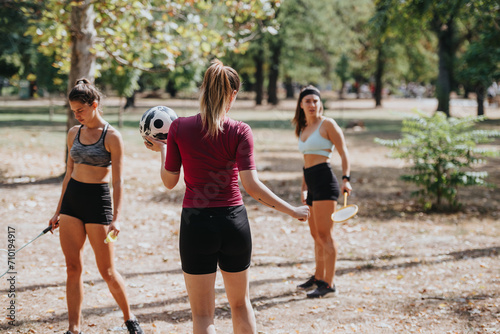 Fit athletes playing badminton in a park. Enjoying a sunny day outdoors, surrounded by trees. Active and motivated, having fun while exercising.