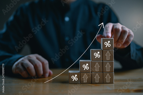 Investor trader businessman with interest rate and dividend concept, wooden block with percentage symbol, up arrow, return on stocks and mutual funds, long term investment for retirement. photo
