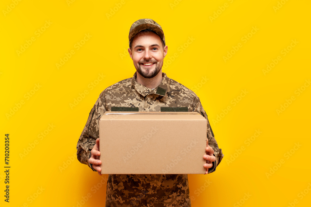 young Ukrainian male soldier in camouflage pixel uniform holding a box ...