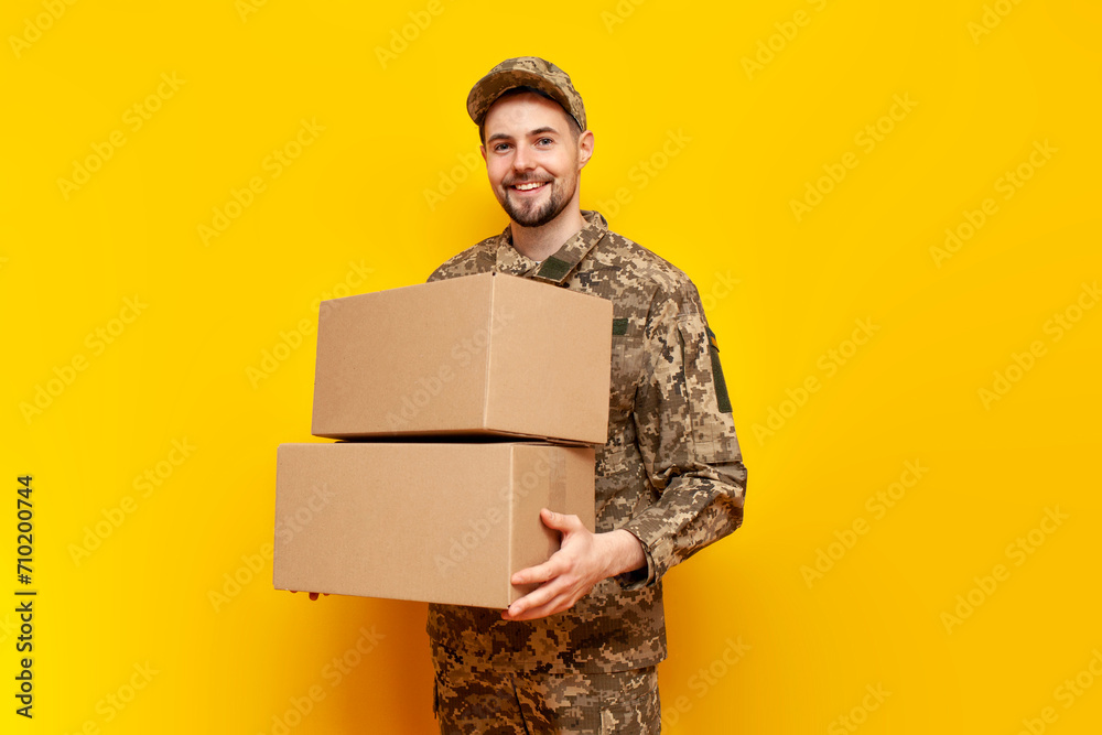 young Ukrainian male soldier in camouflage pixel uniform holding a box ...