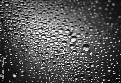 Abstract black and white background with shiny brilliant water drops dew or rain on the glass with r